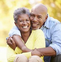senior couple where the husband is hugging his wife from behind