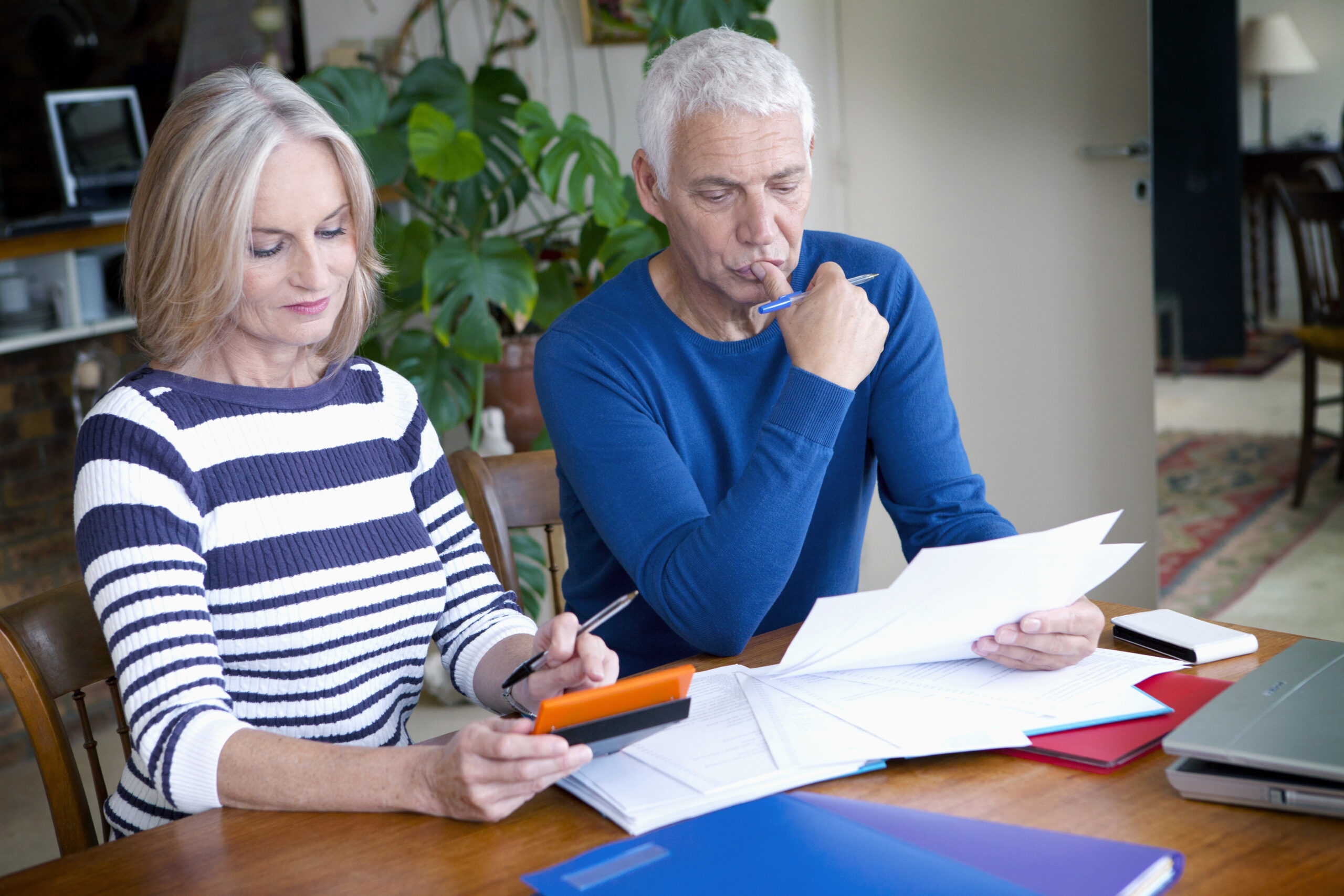 senior couple looking confused while reviewing Medicare paperwork